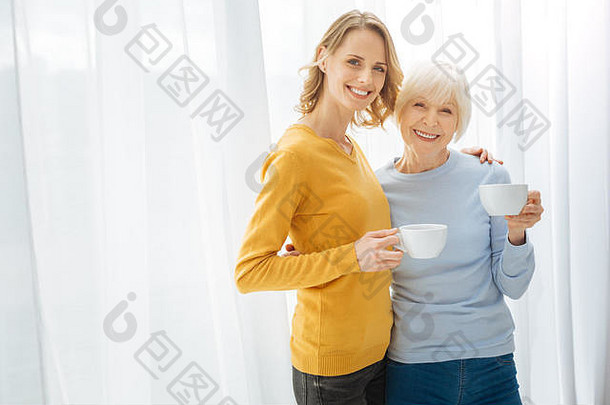 积极的可爱的亲戚拥抱微笑喝茶