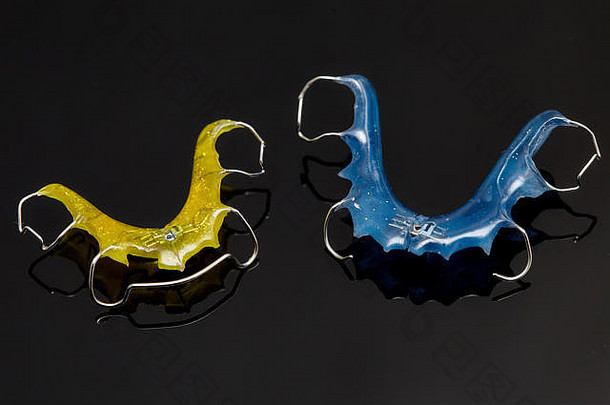黑色玻璃背景上的彩色牙套或牙齿固定器，特写