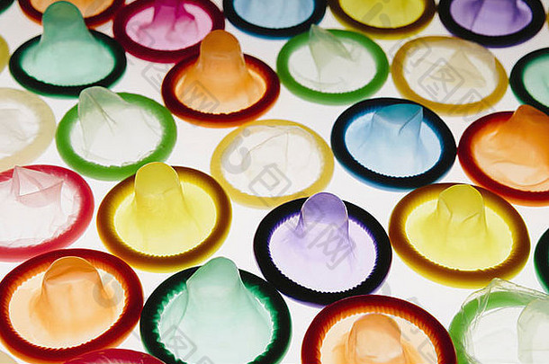 一<strong>大</strong>群五颜六色的避孕套整齐地摆放在白色背景上