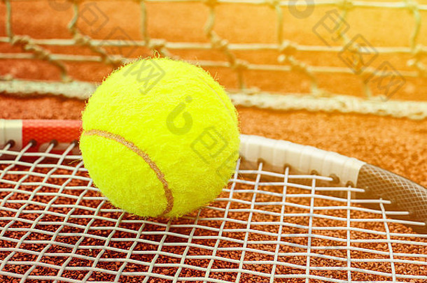 带球的网球拍在粘土场地上的粘土上