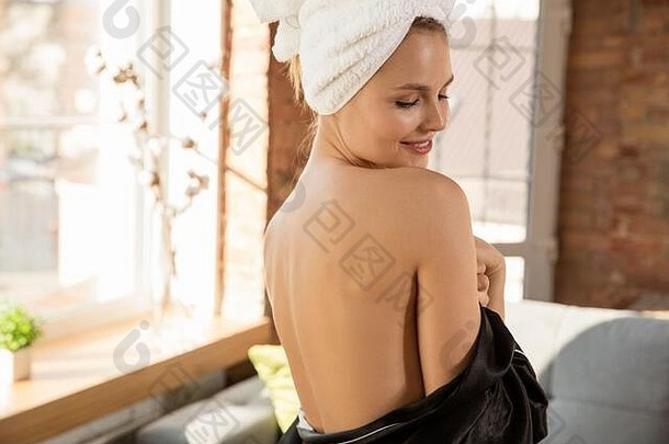 选美日。穿着丝绸长袍的女人在家里做日常护肤。摆姿势，看起来很满意，显示了面部和背部保持良好和健康的皮肤。<strong>美容</strong>、自我护理、<strong>化妆</strong>品、青<strong>春</strong>的概念。
