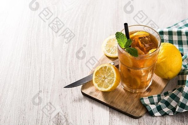 冰茶饮料，柠檬装在玻璃杯里，冰放在白色木桌上