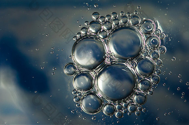 由水面上的油制成的蓝色抽象气泡