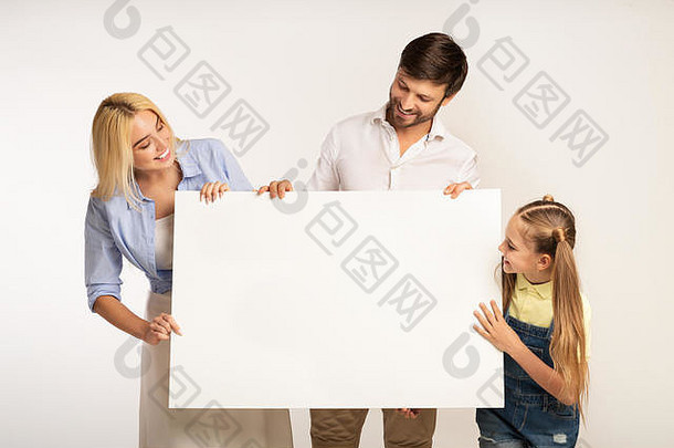 幸福的家庭拿着白色的白板站在白色的背景上