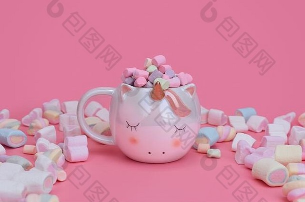 粉色背景上的睡麒麟杯，混合棉花糖，放置文本。Sweets概念与拷贝空间。不同颜色