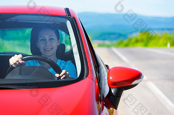 坐在红色汽车里的女人。