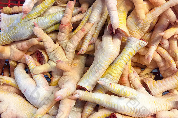 特写一堆生鸡脚，供厨师在新鲜市场出售。