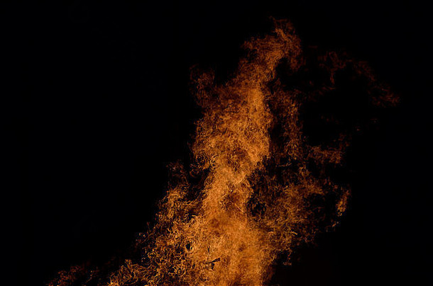 在黑暗的冬季背景下，篝火中燃烧着美丽的炽热火焰