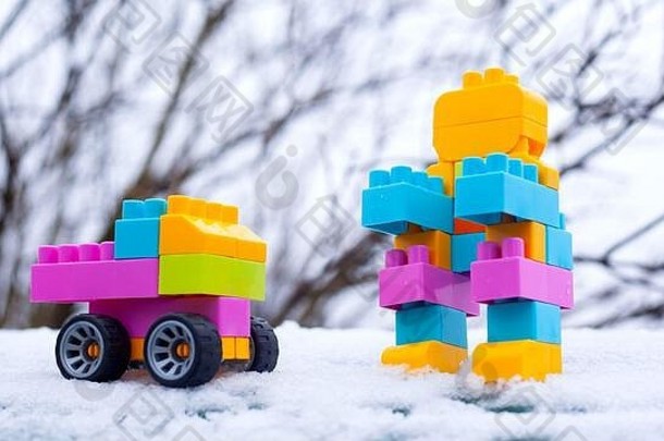 冬季新年儿童玩具汽车和机器人。街上雪地里的玩具。克里斯特马斯的礼物。