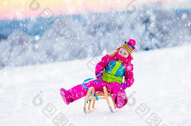 小女孩喜欢坐雪橇。儿童雪橇。蹒跚学步的孩子骑着雪橇。孩子们在户外雪中玩耍。孩子们在威斯康星州的阿尔卑斯山上滑雪