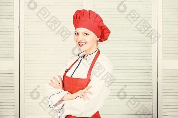 戴厨师帽和围裙的女人。厨房里的专业厨师。烹饪快乐女人用食谱烹饪健康食品。有厨具的家庭主妇。有用的技术。食物介绍。