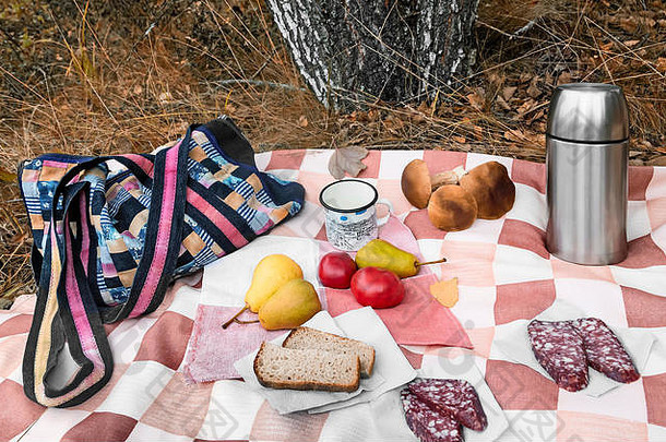 在森林里的一块空地上，桌布上躺着早餐：香肠、面包、咖啡、水果。接下来是收获的蘑菇盒。