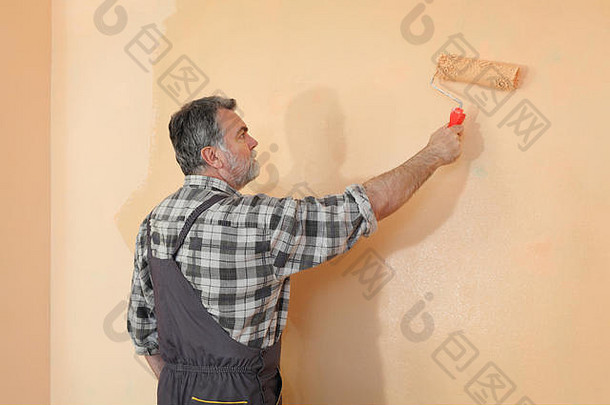 工人绘画墙房间橙色颜色油漆辊