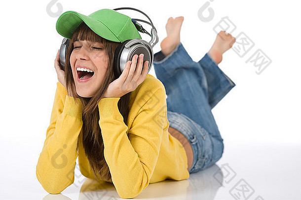 快乐的少女喜欢白色背景的音乐，戴着耳机和棒球帽
