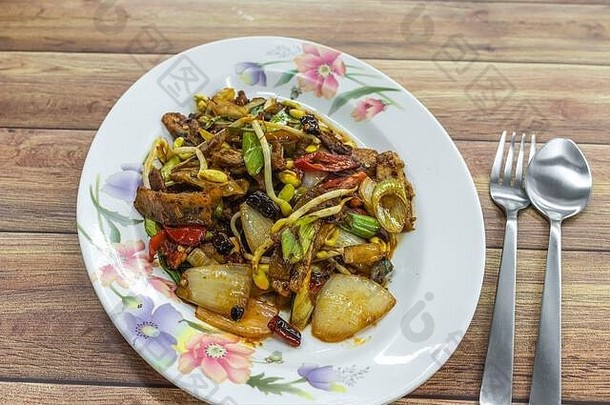 用豆芽、干辣椒和葱炒香辣牛肉片。正宗的中国亚洲食物摆在桌上。