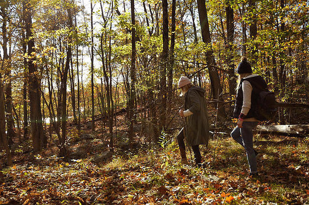 徒步旅行营冒险旅行友谊概念女孩走秋天森林山