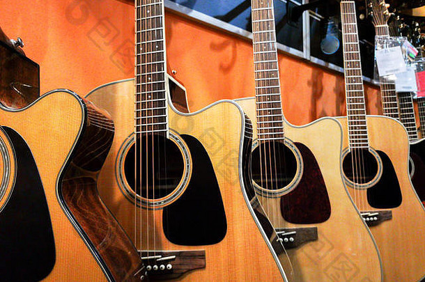 金属弦原声吉他挂在音乐商店的<strong>墙</strong>上，随时可以演奏