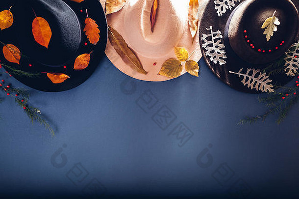 秋季女装。一套三顶羊绒帽子，灰色背景，饰以落叶。时尚与配饰概念。拷贝空间