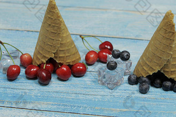 浆果冰淇淋。在木制背景上，各种新鲜蓝莓、樱桃和华夫饼蛋卷平铺在一起。夏季甜<strong>点菜单</strong>概念。冰淇淋制作