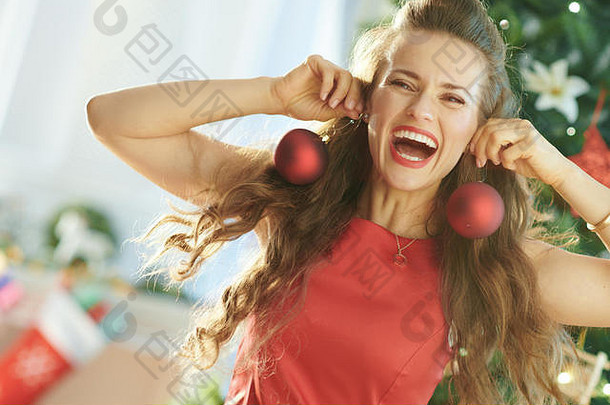 快乐年轻的女人红色的衣服圣诞节树有趣的时间