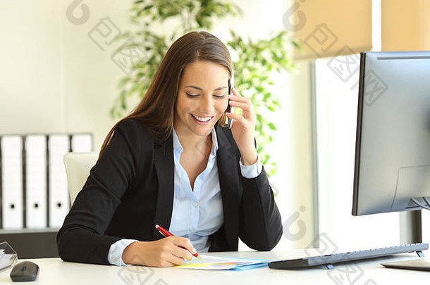 快乐女商人调用移动电话采取笔记桌子上办公室