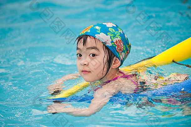 年轻的亚洲女孩享受游泳会话池