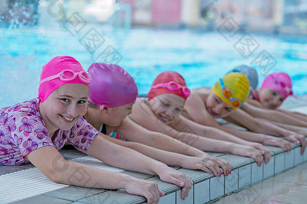 游泳池里快乐的孩子们。年轻成功的游泳运动员摆姿势。
