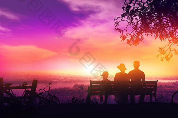 日落时分，一家三口坐在长凳上，欣赏着美丽的河景