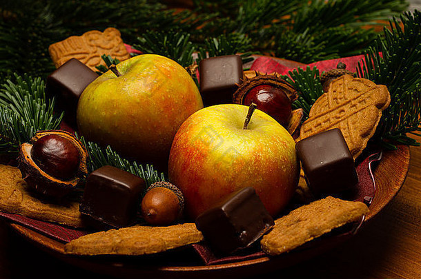 圣诞装饰用杉木、苹果、巧克力、蛋糕、星星装饰在木头上