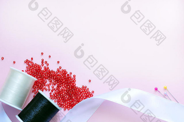 缝纫配件面料光粉红色的背景缝纫线程针针前视图平