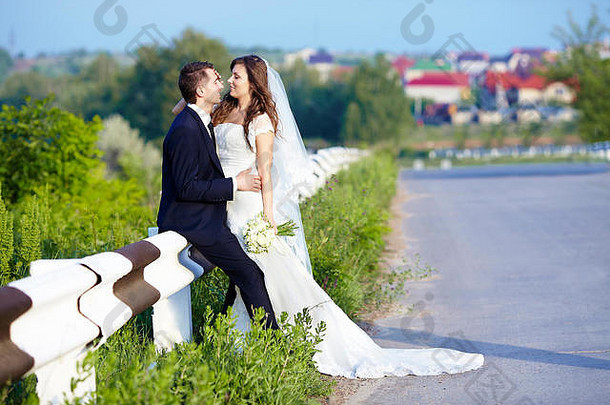 幸福的新娘和新郎在婚礼的路上笑着