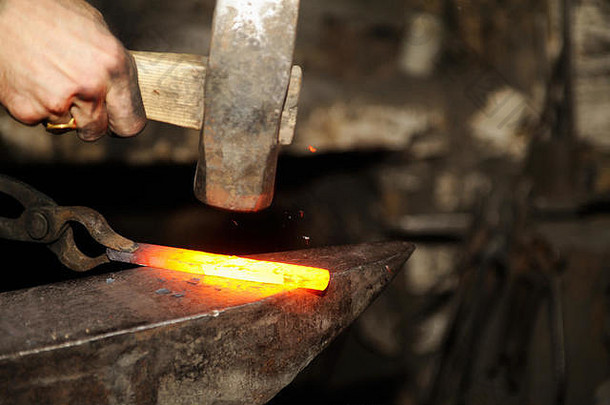 铁匠用锤子在铁砧上锻造金属