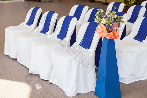 用白色和蓝色的<strong>布</strong>和花装饰的漂亮的椅子