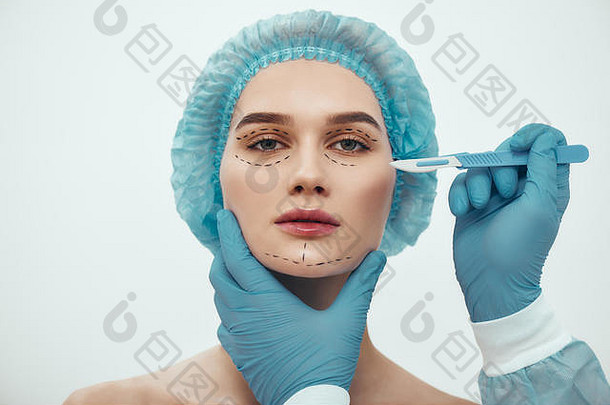 脸电梯手术肖像美丽的年轻的女人蓝色的医疗他化妆品脸手术塑料外科医生蓝色的手套持有手术刀美概念