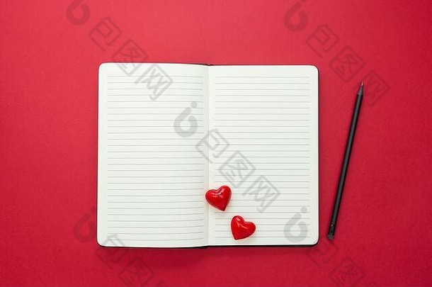 情人节。打开带有红色心形和铅笔的笔记本，在红色背景上，文本空间。
