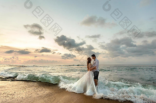 新娘新郎拥抱海滩站海水