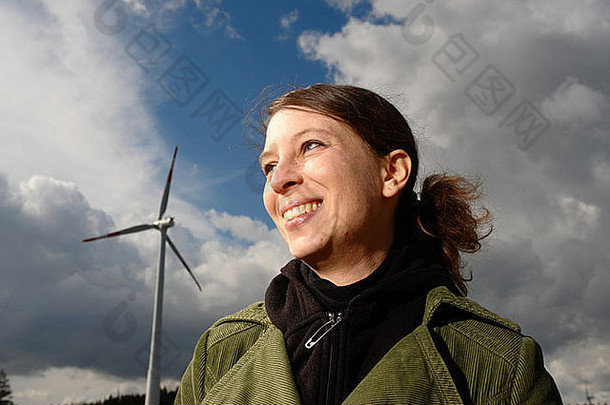 蓝天下的一个女孩背景是一个风电场