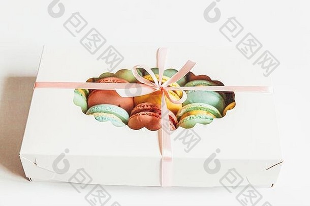 甜杏仁色粉红蓝黄绿色杏仁饼或杏仁饼甜点蛋糕，置于白色背景的礼品盒中。法国甜饼。最低限度的食品烘焙概念。平面俯视图空间
