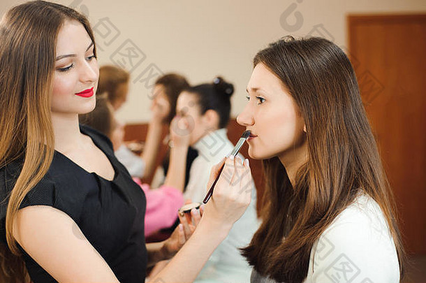 专业化妆艺术家工作美丽的年轻的女人