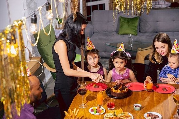 肖像快乐多民族家庭庆祝生日首页大家庭吃蛋糕喝酒问候有趣的孩子们庆祝活动家庭聚会，派对首页概念