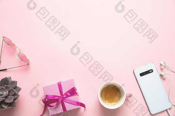 妇女节礼物，办公桌。粉色背景下的礼品盒、手机和咖啡杯、复印空间