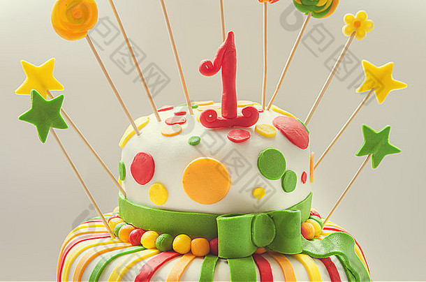 生日蛋糕的细节，五颜六色的装饰和顶部的第一名。