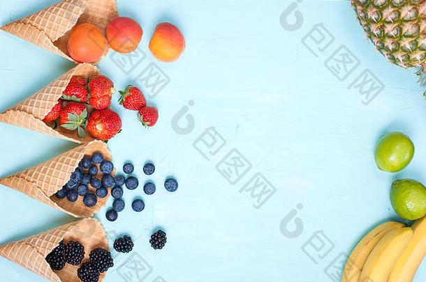 蓝色背景上有不同的浆果和华夫饼干。文本的可用空间。空间，平面布置，上方