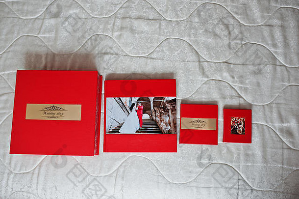 优雅的红色婚礼相册或相册，在柔和的蜡笔背景上刻有金色铭文。