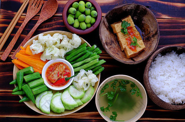 俯视图：素食主义者托盘食物，煮过的蔬菜，如胡萝卜、葫芦、秋葵、菜豆、花椰菜、豆腐奶酪、炸豆腐番茄酱、米饭