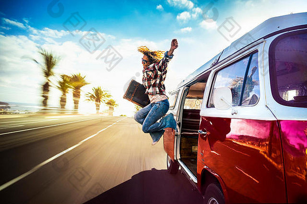 快乐的中年妇女跳出一辆红色的老式面包车，在路上快速行驶，为的是开始度假或冒险的喜悦——流浪癖