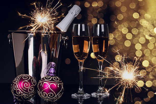 两个酒杯，黑色背景，配香槟、酒瓶、气泡和圣诞装饰品。空间。圣诞快乐，新年快乐，回来