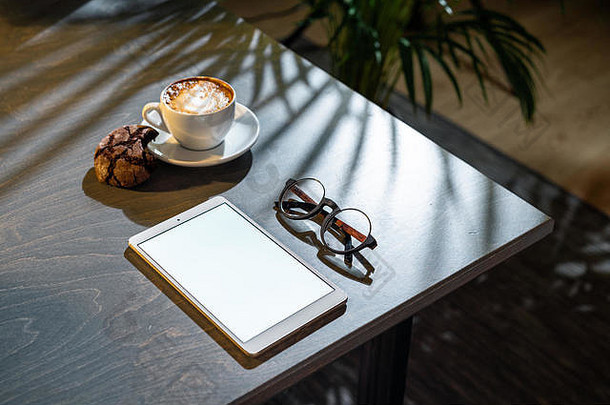 屏幕上有咖啡垫，桌子上有空白的杯子。
