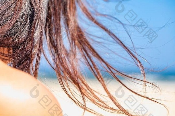 海景、海滩和女人的头发。女孩和她顽皮的长发在强风中飘扬。