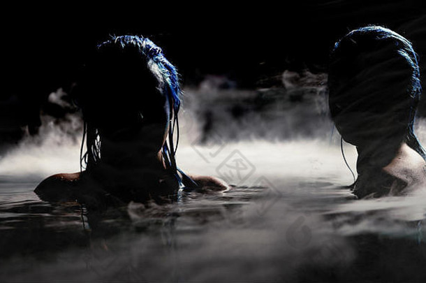 夜晚的汽笛声。两个神秘的汽笛声在浓雾笼罩的水中响起。女模特的夜景。明亮的蓝色头发和定制美人鱼化妆品带来了这一点